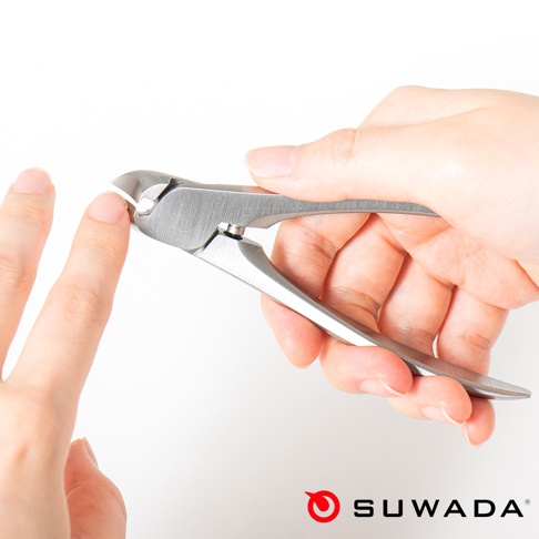 一只手正用銀色金屬材質的日本職人指甲剪修剪另一隻手的手指甲。