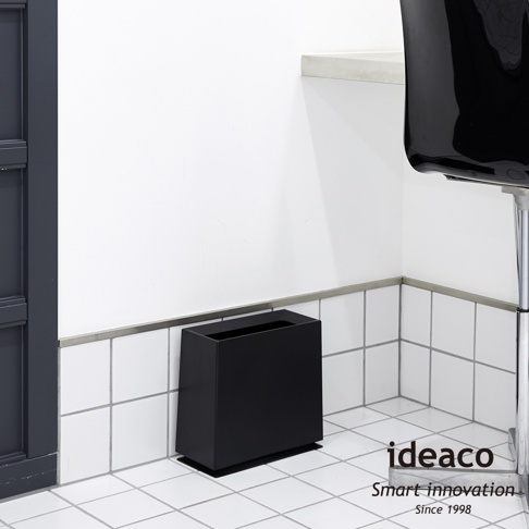 簡約黑色方形垃圾桶，8.5公升容量，材質為塑膠，設計用於居家空間，放置於白色磁磚牆角。