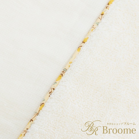 今治純棉浴袍，象牙白，一面為素色棉質，另一面為絨毛棉質，兩者間以印有黃色小花圖案的織帶拼接。