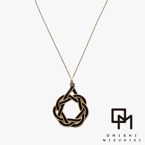 一條細長的金色項鍊，墜飾為一個以深棕色細線編織而成的日式水引花結，呈現環狀結構，邊緣點綴金色細絲。