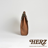 職人手作皮革復古口金後背包，側邊視角，展現溫潤的棕褐色皮革質感與簡約設計。