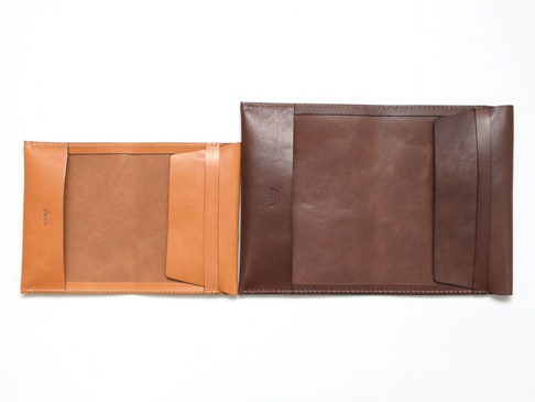 職人手作皮革翻蓋記事本書套，左邊為淺棕色皮革，右邊為深棕色皮革，兩者皆為可放入筆記本的內頁設計，有著簡潔的翻蓋式外觀。