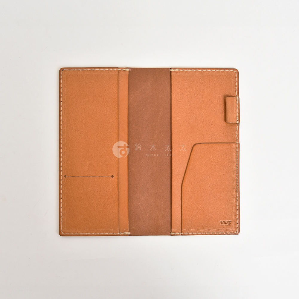 職人手作皮革旅行記事本書套，淺棕色牛皮製成，內有兩格卡槽、一個筆插及一本棕色內頁，縫線細緻，質感樸實。