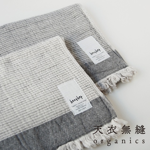 兩條 HEATHER 有機混紡棉浴巾，以灰白色條紋織物製成，帶有流蘇邊飾。