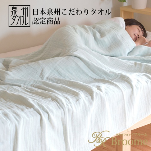 淺藍色四層紗毛巾毯覆蓋在床上，一位女士蓋著毛巾毯熟睡。毛巾毯材質輕盈，觸感柔軟，呈現出自然的皺褶紋理。