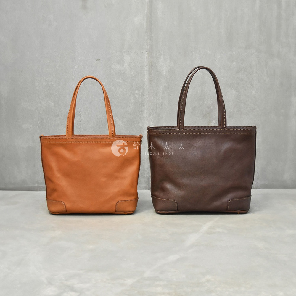 兩個皮革托特包，一個為棕褐色，另一個為深棕色，均帶有簡潔的設計和頂部提把。