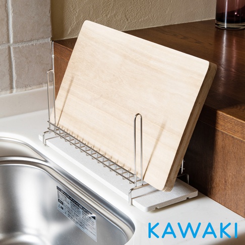一個淺灰色珪藻土材質的瀝水板，上面放置一個金屬支架，支架上立著一片木質砧板。