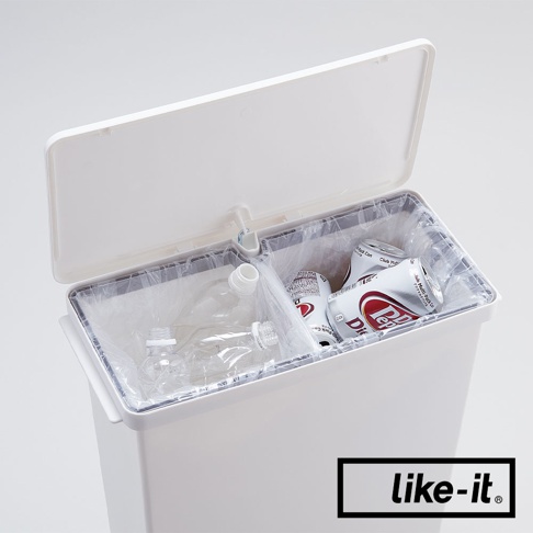 白色直立型腳踏式分類垃圾桶，頂蓋打開，內部有兩個隔間，左側隔間裝有透明塑膠空瓶，右側隔間裝有兩個鋁製飲料罐。