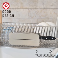 不鏽鋼臥式刀座，銀色，表面光滑，帶有細長切口，可插入刀具。刀柄為黑色，帶有白色鉚釘。刀座置於金屬置物架中，背景為淺色磚牆。