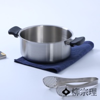 霧面不鏽鋼雙耳鍋，附有黑色隔熱把手，鍋身呈圓柱形，底部平坦。鍋子放在深藍色紋理布墊上，旁邊有一對不鏽鋼夾子。