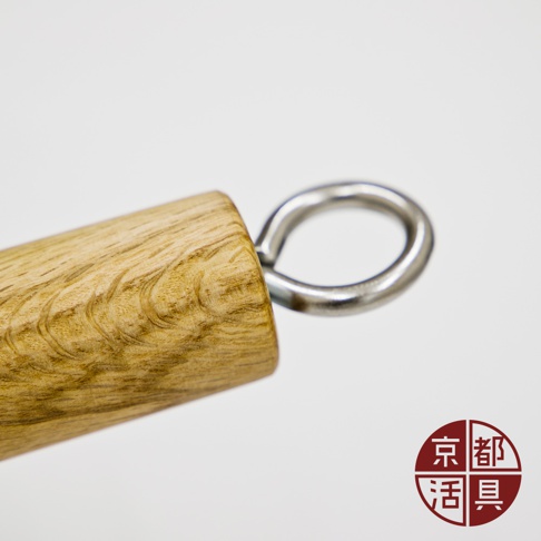 特寫近拍：木質手柄末端有一個金屬掛環，手柄呈現天然木紋，呈淺棕色。