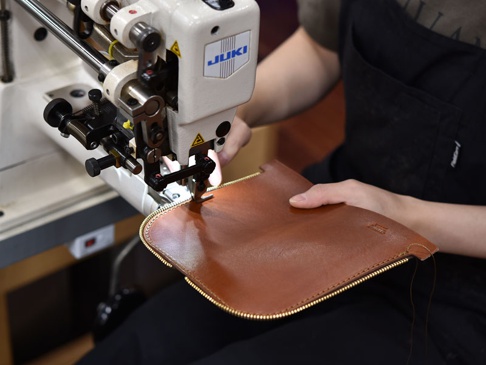 職人手作的棕色皮革筆袋，以 JUKI 縫紉機進行縫製，展現精緻工藝與高品質材質。