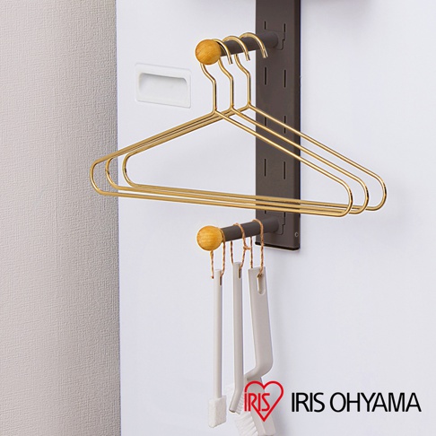 磁吸式收納掛架，深棕色金屬材質，配有四個金色金屬衣架，頂部有圓形木質裝飾，下方掛有三個白色刷子。