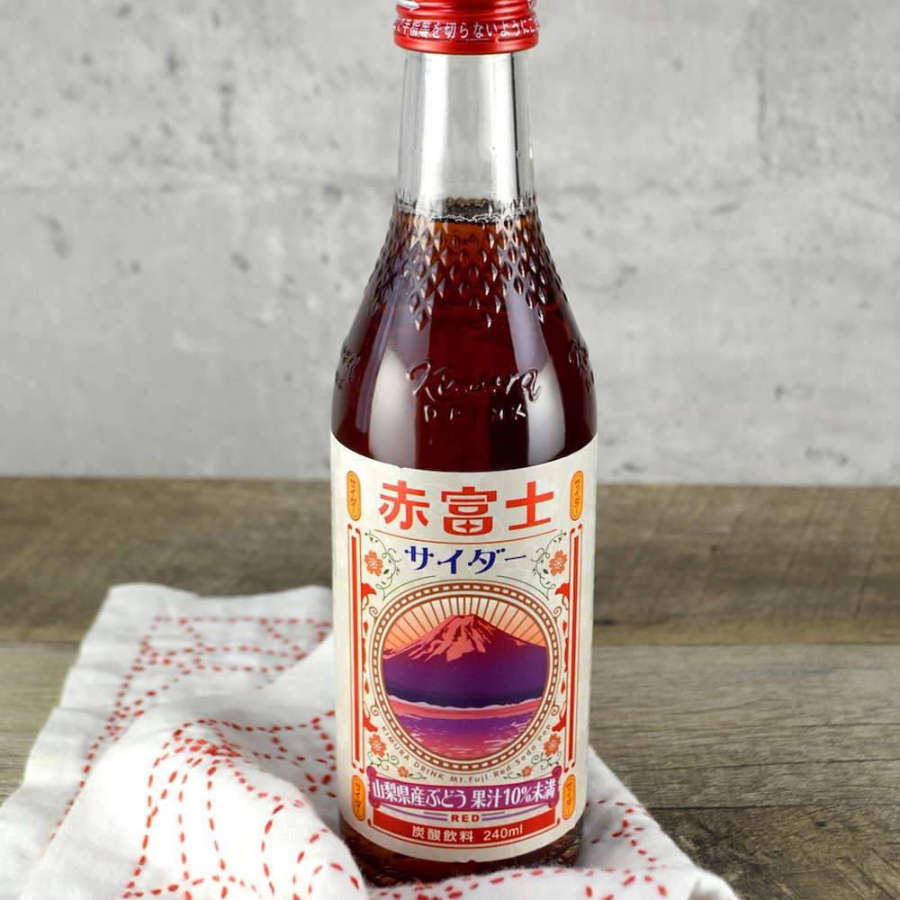木村期間限定汽水，玻璃瓶裝，內含深紅色飲料，瓶身標籤有紅色富士山圖案和日文文字。