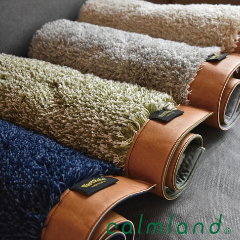Ward Robe 天然防滑玄關地墊，四款顏色，深藍、淺綠、淺灰、米白，材質為柔軟絨毛，以棕色皮革束帶固定捲起。