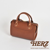 棕色皮革迷你波士頓包，設有頂部提把、金色拉鍊及金色五金配件，包身線條簡潔，展現職人手作質感。