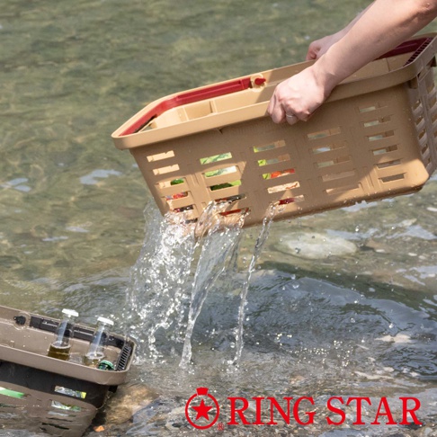 一個淺棕色的塑膠籃子，有紅色的提把，籃身帶有長方形的鏤空設計，正在被傾斜，水從籃子中流出。另一個同款籃子部分浸在水中，裡面有兩瓶玻璃瓶裝的液體。