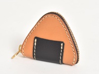 手工皮革零錢包，呈三角飯糰造型，主體為淺棕色皮革，正面中間有一塊黑色皮革裝飾，並以白色縫線點綴，搭配金色拉鍊和鑰匙圈。