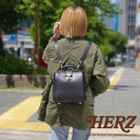 黑色皮革迷你後背包，經典醫生包造型，配有金色旋轉鎖扣和頂部提把，適合隨身攜帶。