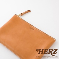 簡潔、描述性的替代文字（alt text）： 一個 tan 色皮革製成長方形拉鍊收納包，帶有同色系皮革拉鍊頭和金屬拉鍊。包面上壓印有品牌標誌。