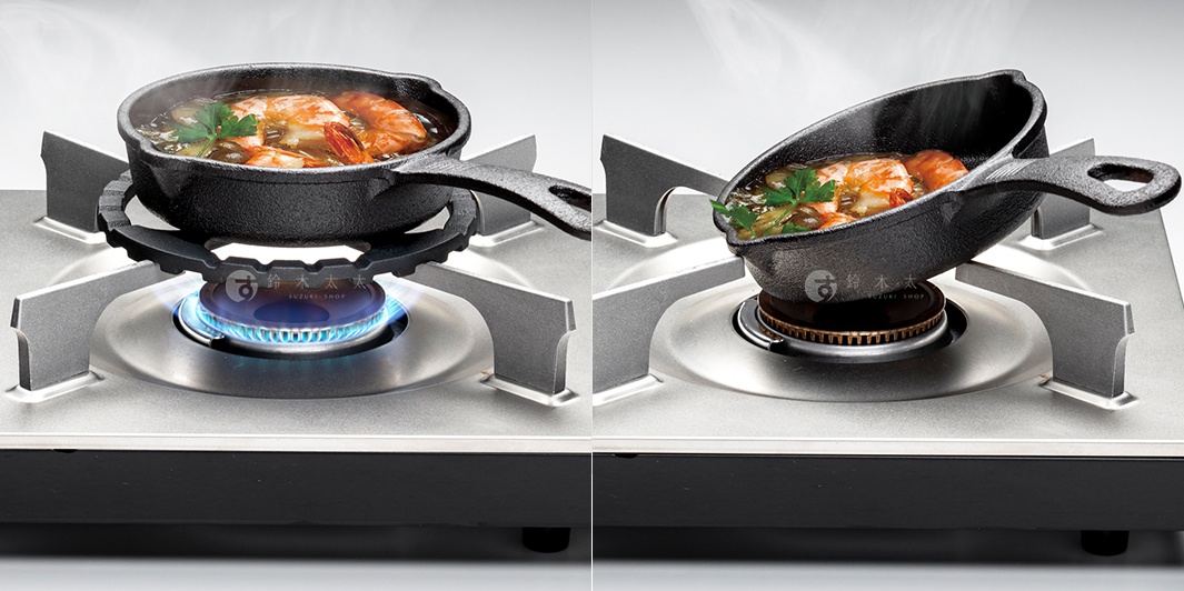 銀色爐架上，黑色鑄鐵小鍋正在烹煮蝦料理，鍋內有蝦、香料及湯汁，爐火為藍色火焰。