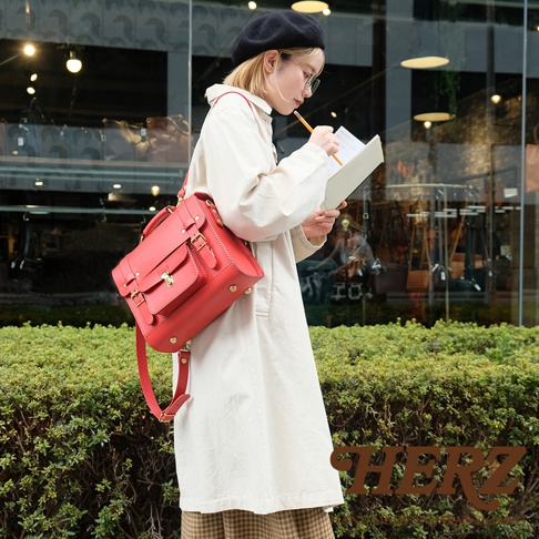 紅色皮革學院風三用迷你後背包，配有兩個前袋、金色鎖扣和可調節肩帶。