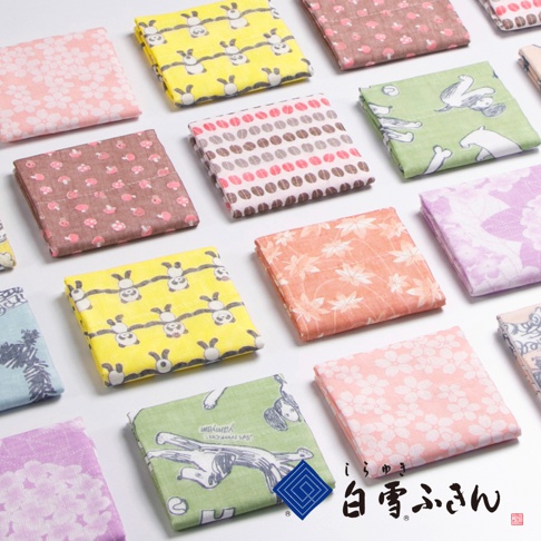 畫面上陳列著十種不同顏色的友禪染畫布風方巾，包含粉色櫻花、黃色熊貓、褐色蘑菇、粉色咖啡豆、綠色奔跑的動物、橘色楓葉、紫色花朵和藍色圖案等，材質輕薄，印有日式傳統圖案。