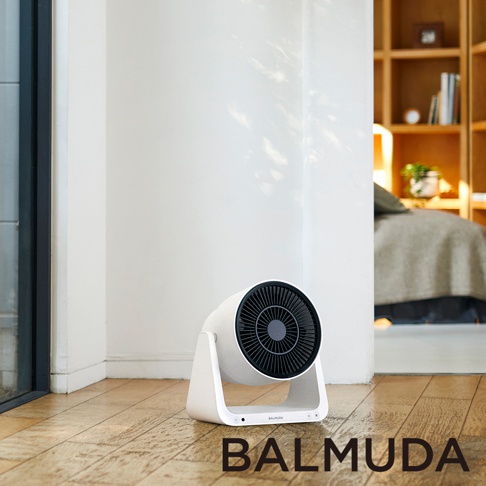 白色與黑色 BALMUDA GreenFan C2 循環扇，帶有現代簡約設計，放置在木地板上，背景為室內房間一角。