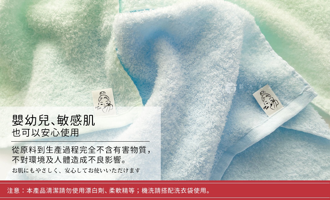 兩條柔軟的毛巾，一條為淺綠色，另一條為淺藍色，材質看起來是絨毛質地，毛巾上縫有印有女性臉部圖案的白色標籤。