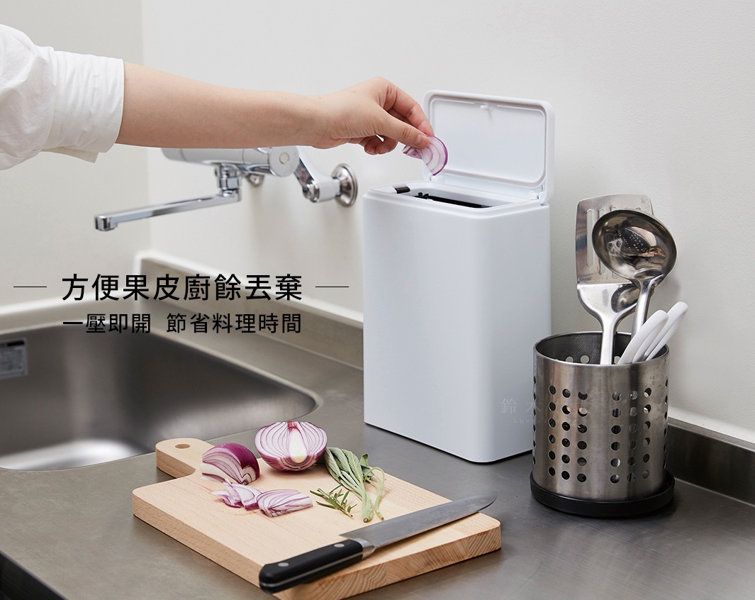 白色防臭按壓式垃圾桶，配有可掀蓋設計，旁邊為金屬餐具收納筒，內含鍋鏟、湯勺及白色餐具。