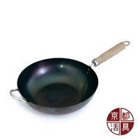 圓底黑色鐵鍋，配有木質手柄及金屬吊環，鍋身兩側有金屬輔助提手。