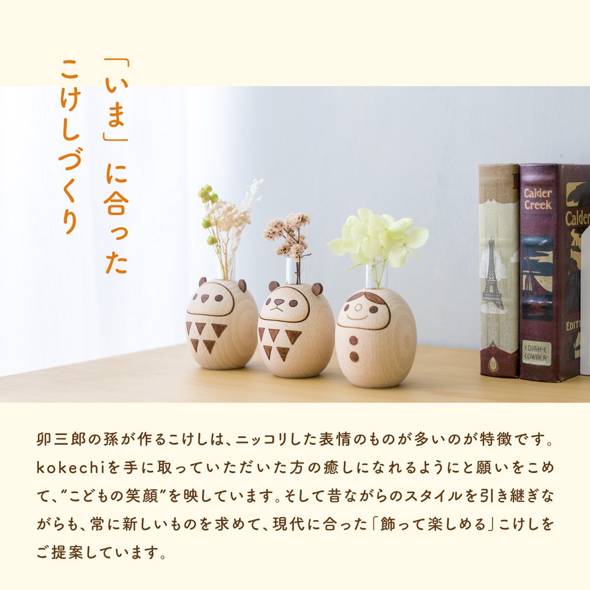 三個木製達摩娃娃擺飾，分別是富士山造型、熊貓造型及男孩造型，娃娃身上有可愛的繪製表情和圖案，每個娃娃頂部都有玻璃瓶可插入乾燥花，背景為淺色，右側有兩本裝飾書籍。