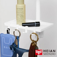 白色塑料置物托盤，附有四個掛鉤，上面擺放著一瓶柑橘香水噴霧和一支黑色筆。托盤下方掛有藍色環保袋、鑰匙圈和一個藍色貓形鑰匙吊飾。