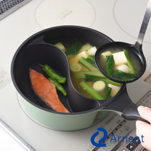 Arnest 雙鍋料理鍋，一邊是煎鮭魚和青辣椒，另一邊是味噌豆腐湯，湯勺正從湯鍋中舀起湯。