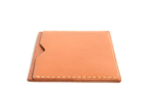 淺棕色皮革製成的職人手作存摺文件收納夾，邊緣有細緻的縫線，側邊有一個V形開口設計，方便拿取文件。