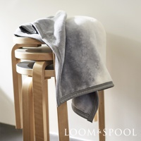 抗菌短絨舒柔單人毯，呈現漸層灰色調，質地柔軟，毯子搭在多層木製圓凳上。