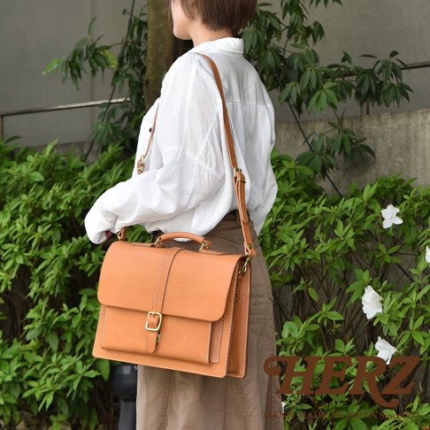 棕色皮革三用商務後背包，配有單扣翻蓋和頂部提把，可肩背或手提。