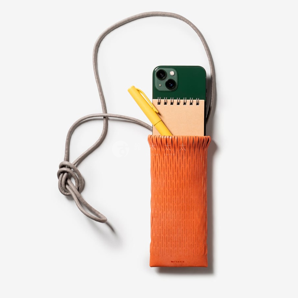 FABRIK 橘色皮革隨形貼合伸縮小包，內含綠色手機、咖啡色筆記本和黃色筆，搭配灰色編織掛繩