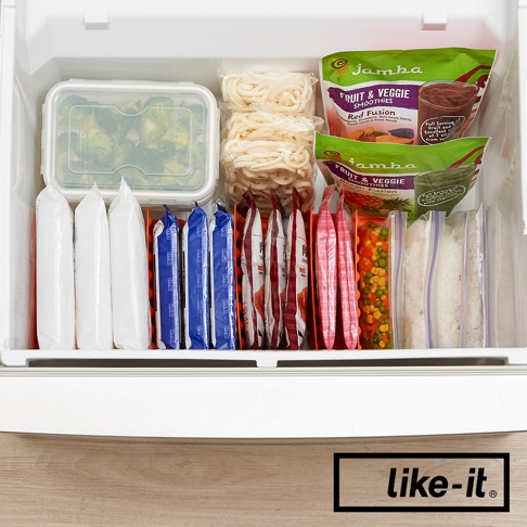 冷凍庫內整齊擺放著白色網格收納盒，內有冷凍食品，包括綠色花椰菜、麵條、水果冰沙包、冷凍蔬菜、以及其他包裝食品。