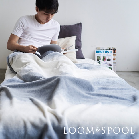 一件抗菌短絨舒柔單人毯，採用漸層藍白配色，質地柔軟，覆蓋在床鋪上。