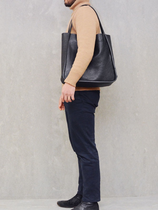 職人手作皮革Organ方形托特包 (G-68) M，黑色皮革，方形輪廓，肩背款式，搭配駝色高領毛衣與海軍藍長褲。