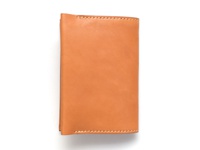 淺棕色皮革翻蓋記事本書套，採用手工縫線裝飾，呈現簡約的設計風格。