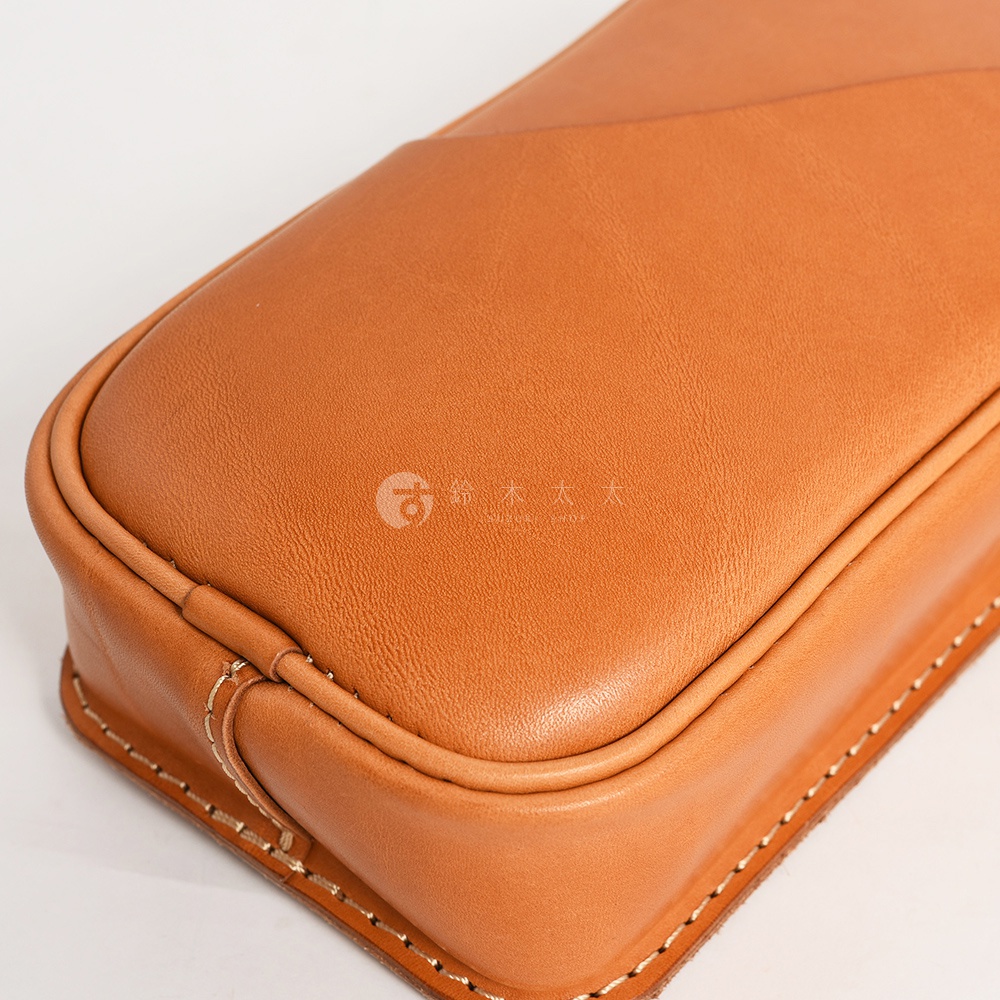 日本HERZ 職人手作皮革兩用直立型斜背包，特寫近拍畫面，展現咖啡色皮革細膩紋理與手工縫線的質感。