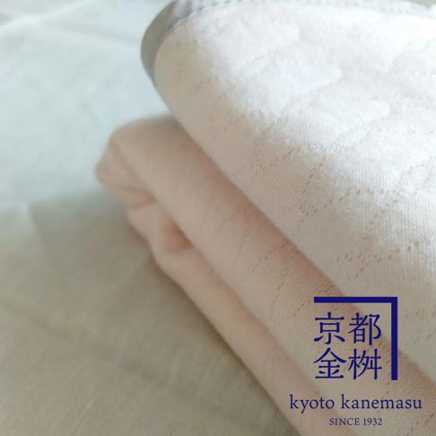 粉色天絲棉絎縫單人毯，帶有細緻的菱格紋理，一角有京都金桝的標誌。