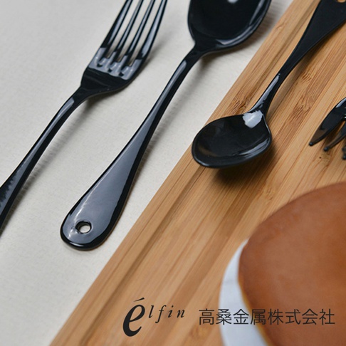 黑色琺瑯水果叉和甜點勺，光滑的表面，細長的握柄，其中一把叉子握柄上有掛孔，擺放在木質托盤上。