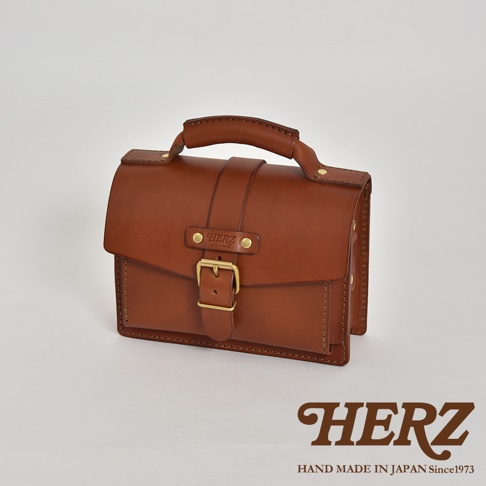 職人手作皮革經典混合風迷你單肩包，採用溫潤的棕色皮革，搭配黃銅色金屬扣環與鉚釘，設計簡約，質感紮實，適合日常攜帶。