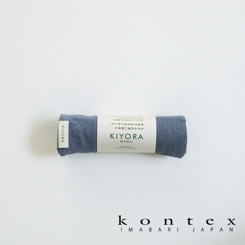 捲起的 KONTEX 品牌 KIYORA MOKU 系列藍灰色備長炭毛巾，包裝紙標上印有產品名稱及日文說明，整體呈現簡潔的日式風格，底部則標示 KONTEX IMABARI JAPAN 字樣。