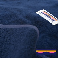 深藍色毛絨睡袋毯，帶有標誌性彩色幾何圖案織標。