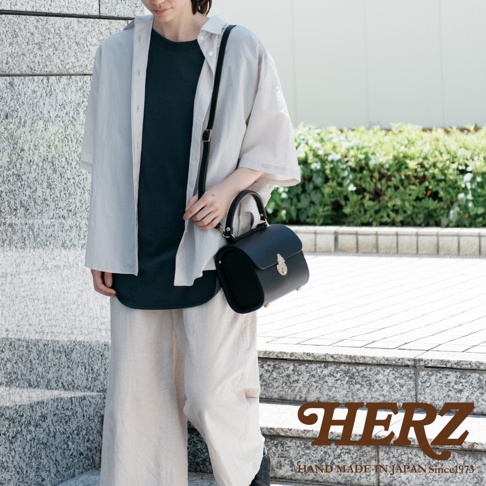 職人手作皮革復古杜勒斯手提包，黑色，配有可調節肩帶和頂部提把，正面飾有金色搭扣。