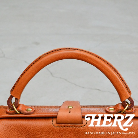 職人手作皮革Organ兩用方形口金托特包，細節展示提把、金屬扣環與壓紋皮革，整體為棕褐色。